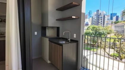 Sacada com churrasqueira a carvão — foto real do apartamento decorado